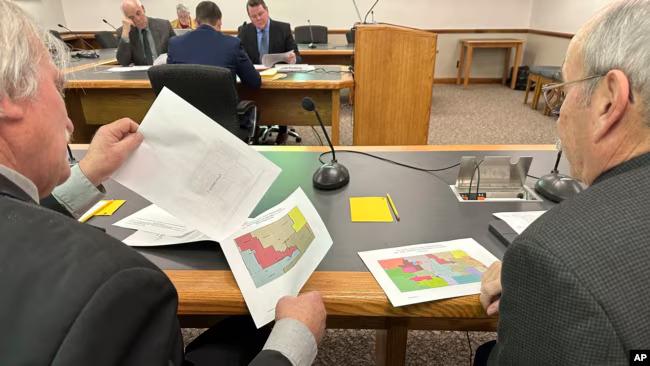 North Dakota state Rep. Robin Weisz, left, and state Sen. Jerry Klein, both Republicans, inspect alternative maps proposed by the Turtle Mountain Band of Chippewa Indians and the Spirit Lake Tribe, on Dec. 5, 2023.